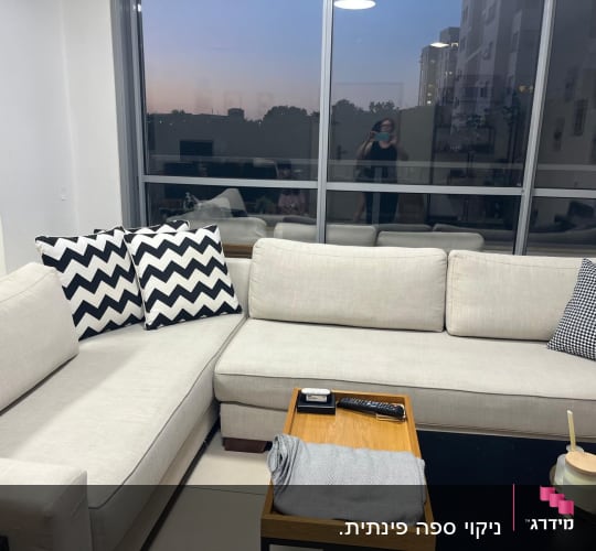 ספה בהירה עם כריות מעוצבות ושולחן קטן